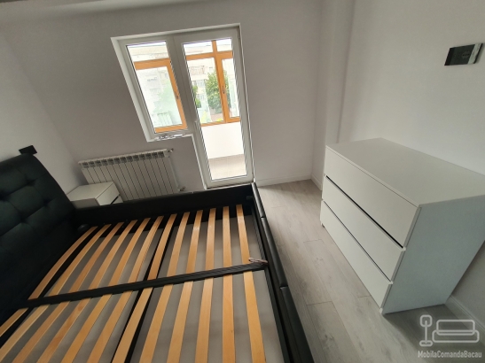Mobilier de dormitor din PAL cu pat tapițat și comodă cu profile Gola negre