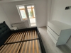 Mobilier de dormitor din PAL cu pat tapițat și comodă cu profile Gola negre