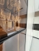 Bucătărie mdf vopsit & furniruit pe colț, 6900 mm – blat/contrablat din quartz, mânere gola negre, cămară integrată