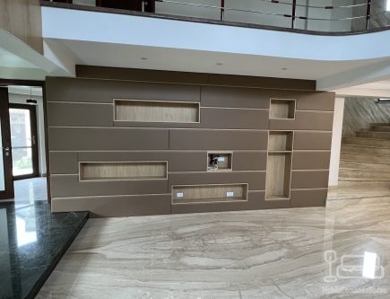 Perete tapițat din piele, cu nișe decorative și integrare electrică