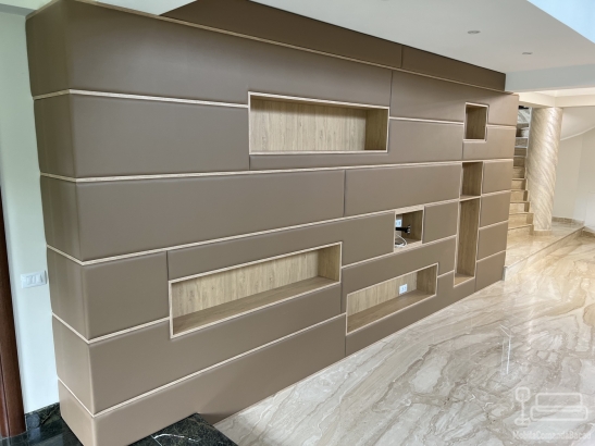 Perete tapițat din piele, cu nișe decorative și integrare electrică