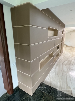 Perete tapițat din piele, cu nișe decorative și integrare electrică