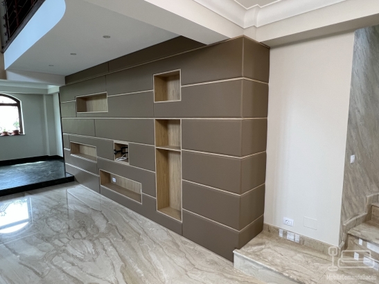 Perete tapițat din piele, cu nișe decorative și integrare electrică