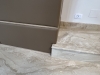 Perete tapițat din piele, cu nișe decorative și integrare electrică