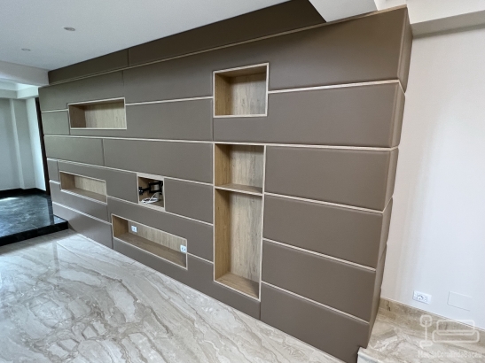 Perete tapițat din piele, cu nișe decorative și integrare electrică