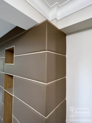 Perete tapițat din piele, cu nișe decorative și integrare electrică