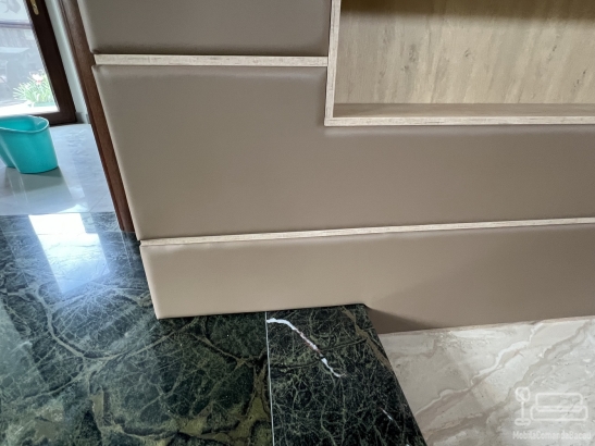 Perete tapițat din piele, cu nișe decorative și integrare electrică