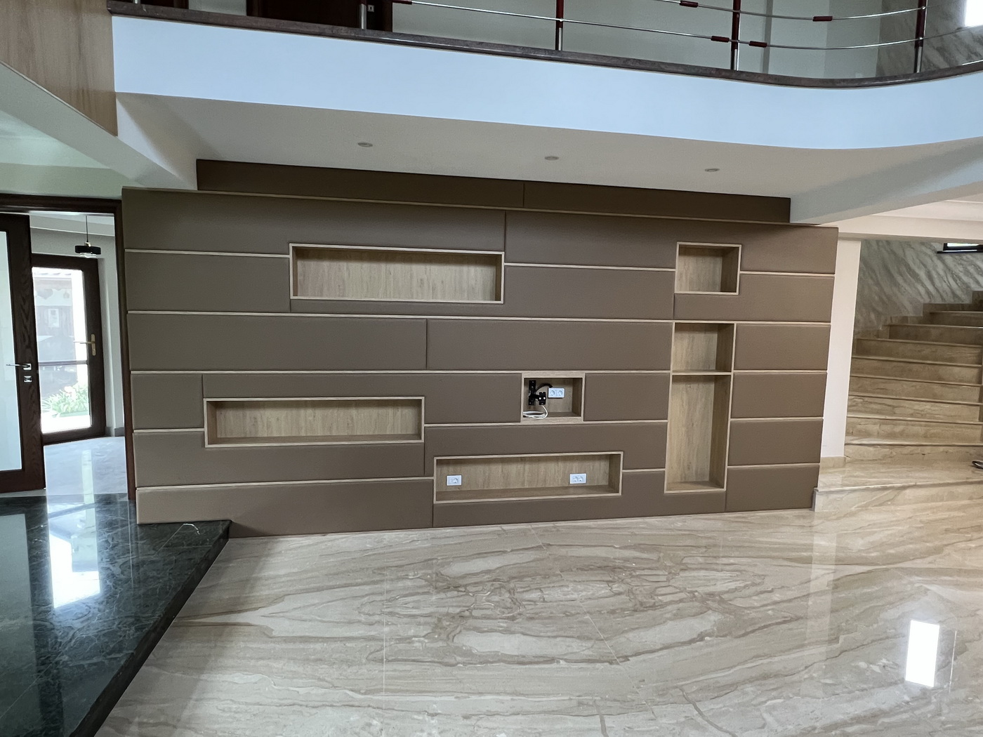 Perete tapițat din piele, cu nișe decorative și integrare electrică